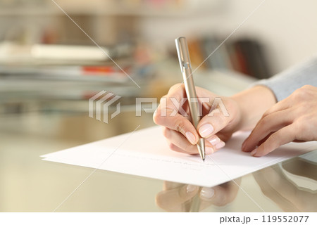 Woman hands writing letter on paper sheet on table Woman hands writing letter on paper sheet on table 119552077