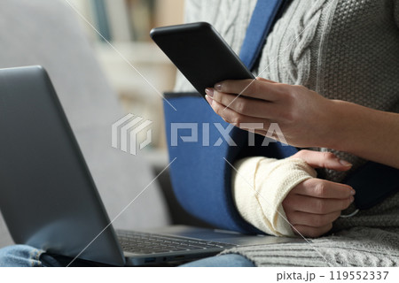 Disabled woman with broken arm using smartphone 119552337