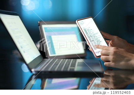 Woman hand using multiple devices at home in the night Woman hand using multiple devices at home in the night 119552403