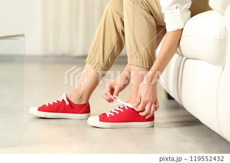 Woman hands tying shoelaces at home Woman hands tying shoelaces at home 119552432