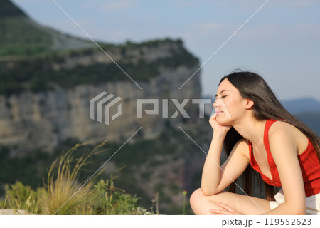 Asian woman in red resting in the mountain Asian woman in red resting in the mountain 119552623