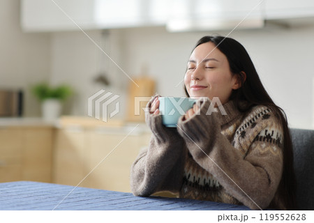 Asian woman in winter relaxing smelling coffee 119552628