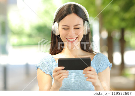 Front view of an asian woman watching videos on phone Front view of an asian woman watching videos on phone 119552697