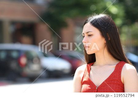 Serious asian woman looking away in the street 119552794