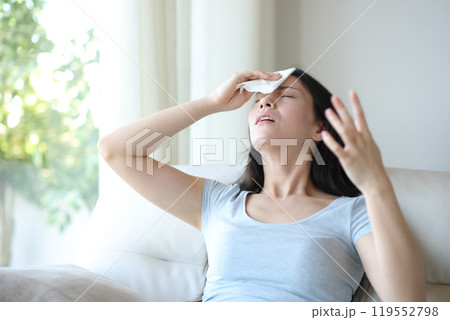 Stressed asian woman drying sweat suffering heat stroke at home Stressed asian woman drying sweat suffering heat stroke at home 119552798