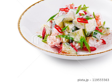 Fresh salad with cucumber and tomato seasoned with red chili pepper on white plate 119555563