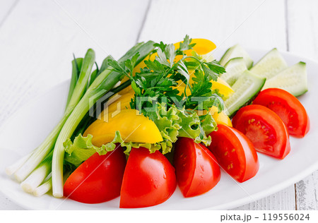 Plate of freshly cut vegetables sitting on white table Plate of freshly cut vegetables sitting on white table 119556024