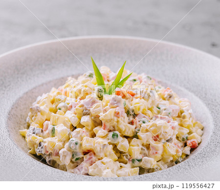 Russian salad with mayonnaise, vegetables and chicken meat being served on the table 119556427