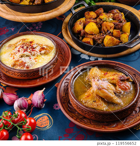 Traditional georgian food served in clay pots standing on a decorated table Traditional georgian food served in clay pots standing on a decorated table 119556652