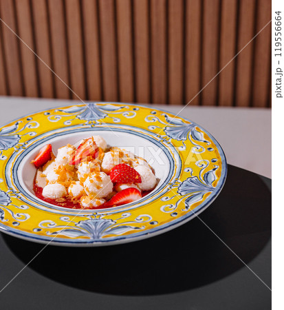 Delicious dessert with strawberries and cream being served on decorated plate Delicious dessert with strawberries and cream being served on decorated plate 119556664