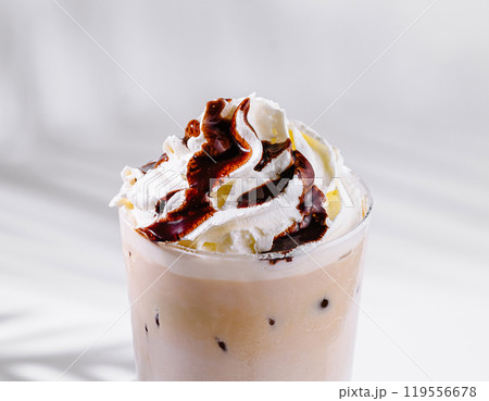 Iced coffee with whipped cream and chocolate sauce on white background 119556678