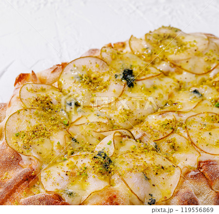 Delicious gourmet pizza with pears, pistachios and blue cheese being baked 119556869