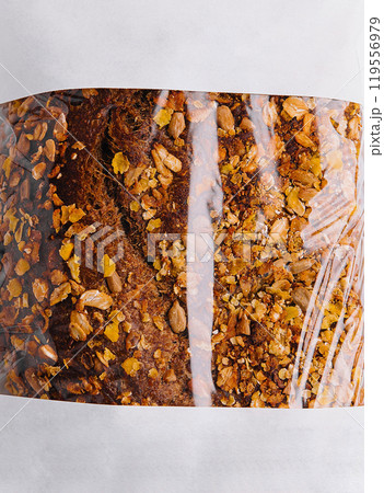 Freshly baked loaf of bread with seeds in paper bag 119556979
