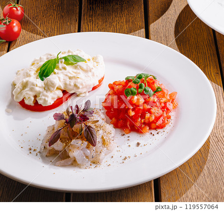Gourmet tomato and cheese appetizers on elegant table setting Gourmet tomato and cheese appetizers on elegant table setting 119557064