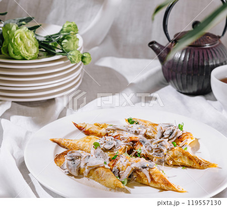 Savory stuffed crepes with mushrooms and creamy sauce on white plate Savory stuffed crepes with mushrooms and creamy sauce on white plate 119557130
