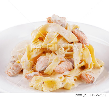 Delicious pasta dish with salmon and creamy sauce on white plate 119557365