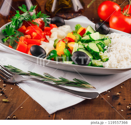 Shopska salad with feta cheese, tomatoes, cucumber and olives resting on a wooden table Shopska salad with feta cheese, tomatoes, cucumber and olives resting on a wooden table 119557366