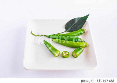 白い皿にのせた緑色の唐辛子 119557488