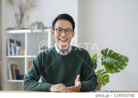 カメラ目線で話す30代後半の男性 119558788