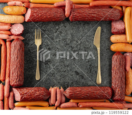 Various dry-cured and smoked sausages on a stone table. Various dry-cured and smoked sausages on a stone table. 119559122