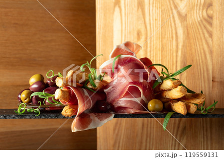 Prosciutto with bread sticks, olives, and rosemary. 119559131