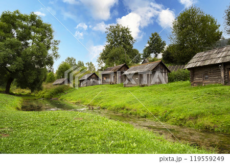 Medieval complex of traditional wooden baths reflected in the water on the bank of the river in the village of Vyatskoye in Yaroslavl region in Russia in the summer 119559249