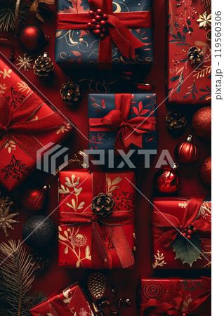 Festively wrapped gifts adorned with ribbons and decorations on a rich red background create a warm holiday atmosphere for celebration. 119560306