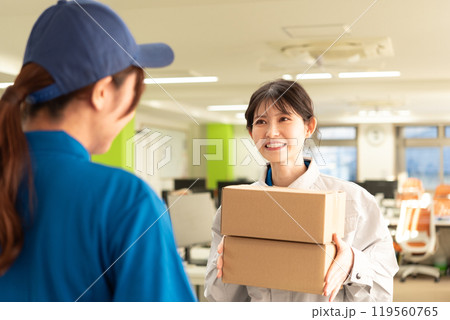 宅配便の荷物を受け取る作業服姿のエンジニアの女性 宅配便の荷物を受け取る作業服姿のエンジニアの女性 119560765