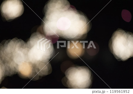 Blurry light bokeh spots on a black background. Festive dark background. 119561952