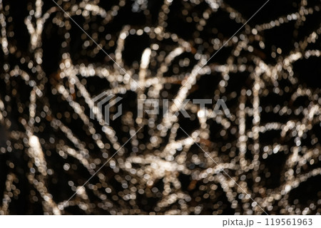 Blurry light bokeh stripes on a black background. Festive dark background. Blurry light bokeh stripes on a black background. Festive dark background. 119561963