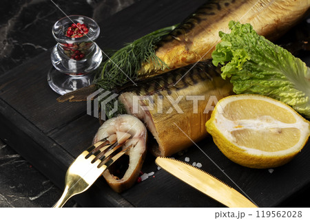 Smoked fish with herbs and lemon on a wooden board. Beautiful mackerel food. Smoked fish with herbs and lemon on a wooden board. Beautiful mackerel food. 119562028