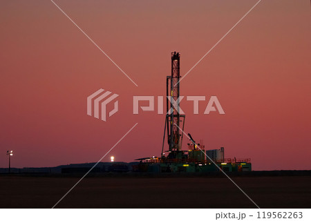 Black silhouette of oil drilling rig in the field at night. Black silhouette of oil drilling rig in the field at night. 119562263