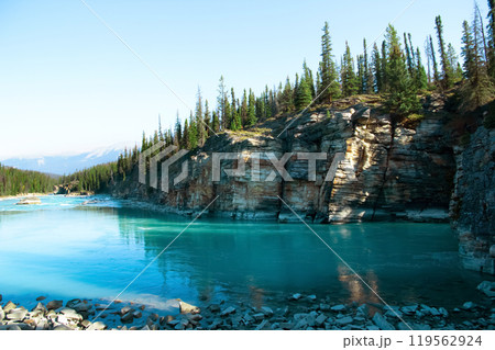 Blue waters of the Athabasca river along mountains and forests. Blue waters of the Athabasca river along mountains and forests. 119562924
