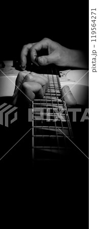 Guitarist Playing Guitar In Studio. Low key of man hand play white electric guitar for songs and cover music or skill practice. Close up of musician playing guitars instrument against black background Guitarist Playing Guitar In Studio. Low key of man hand play white electric guitar for songs and cover music or skill practice. Close up of musician playing guitars instrument against black background 119564271