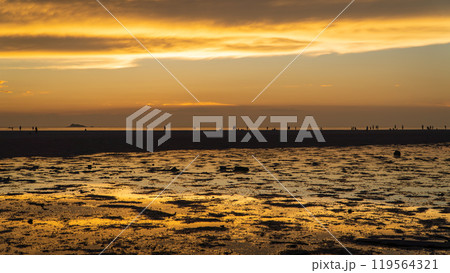 Epic sunset scene on Koh Phangan. The sun's rays illuminate the clouds and the sky is mirrored from the water and sand 119564321
