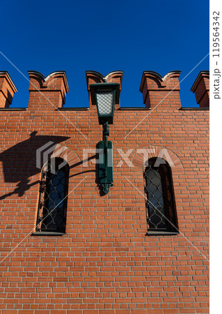 A massive, red-brick wall with small windows and a lantern 119564342