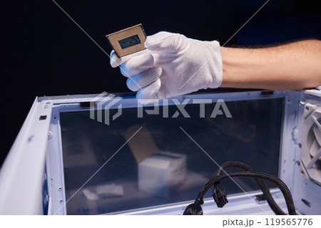 Cropped image of an engineer showing a computer microchip on the foreground 119565776