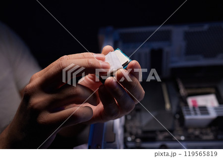 Cropped image of an engineer showing a computer microchip on the foreground 119565819