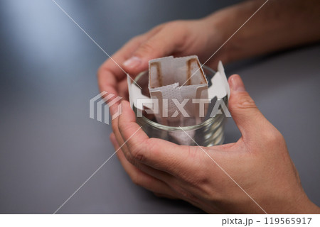 brewing process,a bag filled with boiling water for drip coffee in a cup,top view. brewing process,a bag filled with boiling water for drip coffee in a cup,top view. 119565917