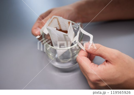 brewing process,a bag filled with boiling water for drip coffee in a cup,top view. 119565926