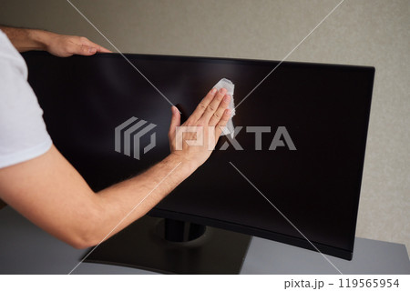 cleaning pc monitor an hand hold a rag 119565954