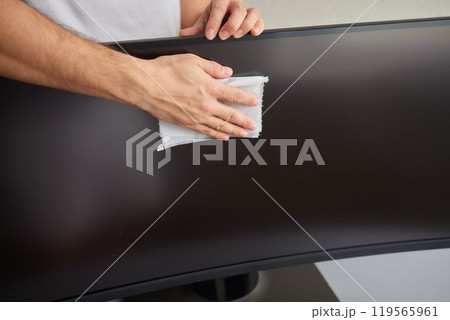 cleaning pc monitor an hand hold a rag 119565961