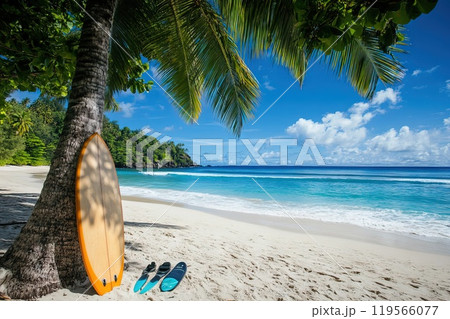 Bright surfboard leaning against a palm tree on a sandy beach overlooking the sea 119566077