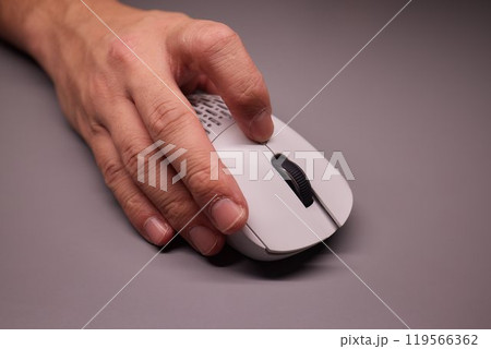 Close-up Macro Shot: Person's Hand Using Wireless Computer Mouse, Scrolls through Apps and Websites with a Wheel and Clicks on Buttons Close-up Macro Shot: Person's Hand Using Wireless Computer Mouse, Scrolls through Apps and Websites with a Wheel and Clicks on Buttons 119566362
