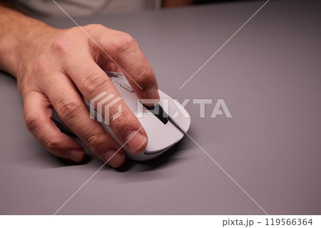 Close-up Macro Shot: Person's Hand Using Wireless Computer Mouse, Scrolls through Apps and Websites with a Wheel and Clicks on Buttons 119566364