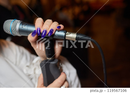 Music artist with body jewelry sings into microphone at concert 119567106