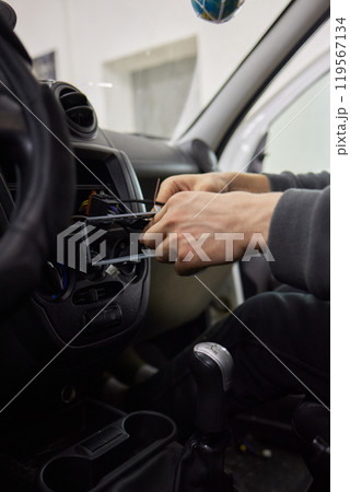 Individual is performing maintenance on the vehicles dashboard Individual is performing maintenance on the vehicles dashboard 119567134