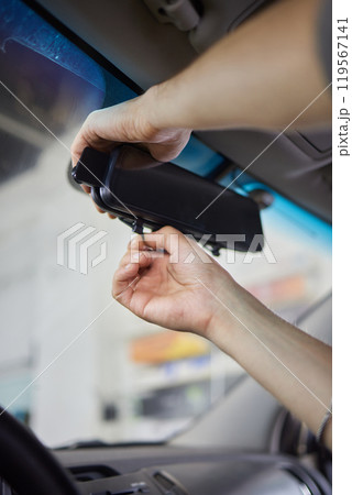 Young woman adjusting smart rear view mirror in car, closeup 119567141