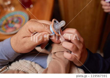 A close up of a persons thumb touching a baby tiny finger 119567391
