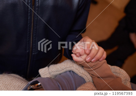 A close up of a persons thumb touching a baby tiny finger 119567393